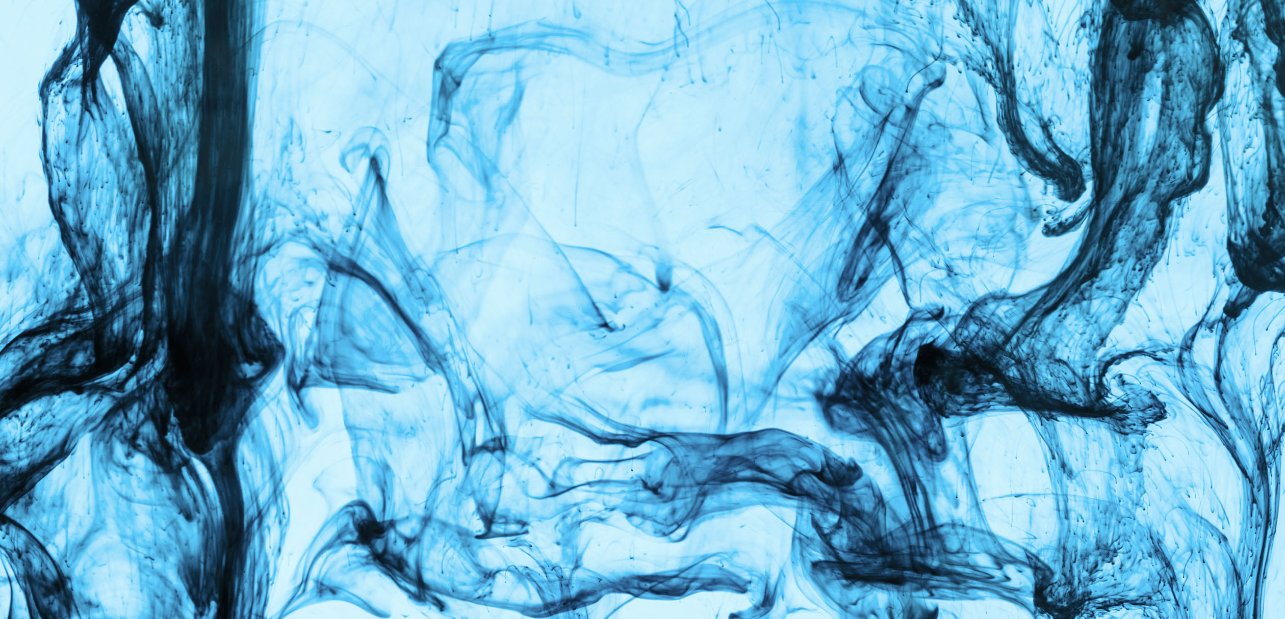 Woman in black glasses and white shirt speaking to a man blurred in the foreground